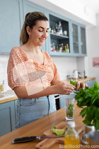 Image of woman making cocktail drinks at home kitchen