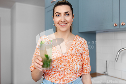 Image of woman with lime mojito cocktail at home kitchen