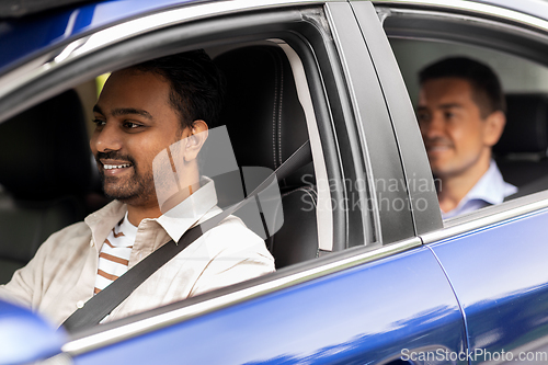 Image of indian male driver driving car with passenger