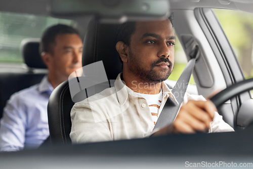 Image of indian male driver driving car with passenger