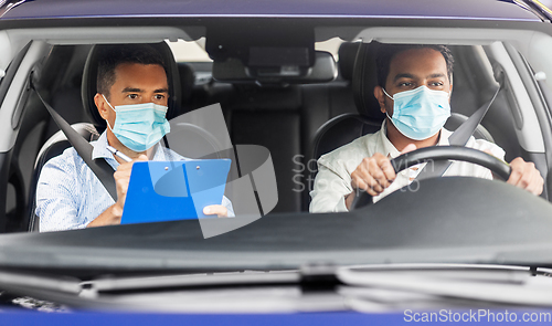 Image of car driving school instructor and driver in mask