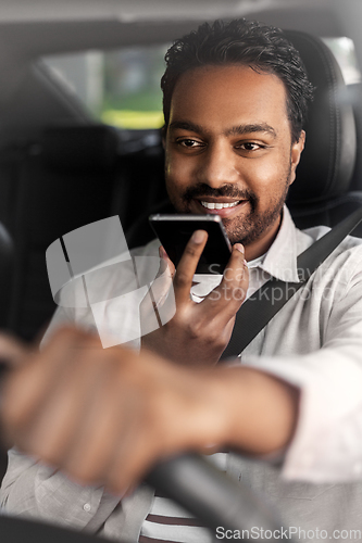 Image of man driving car and recording voice by smartphone