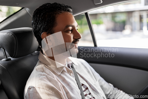 Image of smiling indian male passenger in taxi car