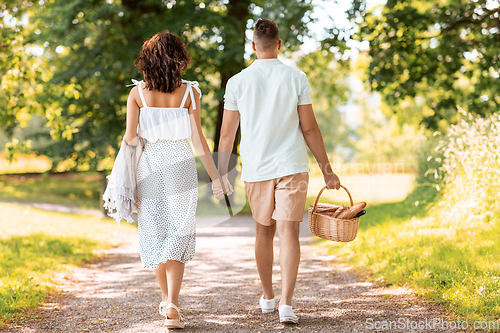 Image of happy couple with picnic basket at summer park