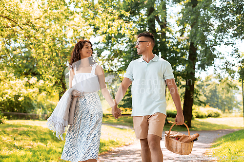 Image of happy couple with picnic basket at summer park