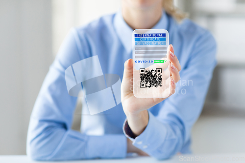 Image of hand with virtual immunity passport on smartphone