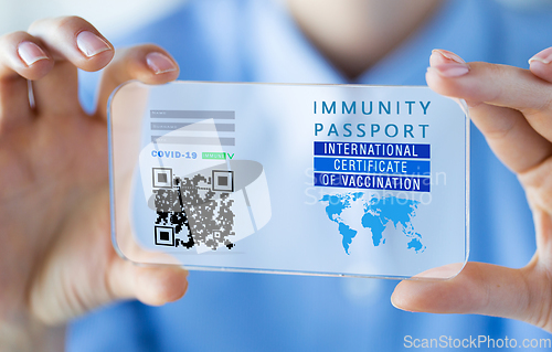 Image of hand with virtual immunity passport on smartphone