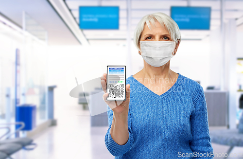 Image of old woman with certificate of vaccination in phone