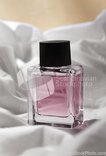 Image of bottle of perfume on white sheet