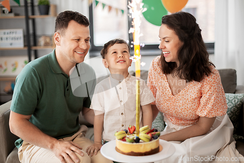 Image of happy family with birthday cake at home