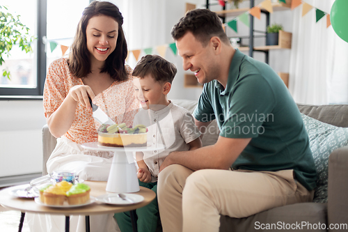 Image of happy family with birthday cake at home