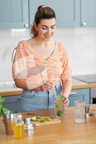 Image of woman making cocktail drinks at home kitchen