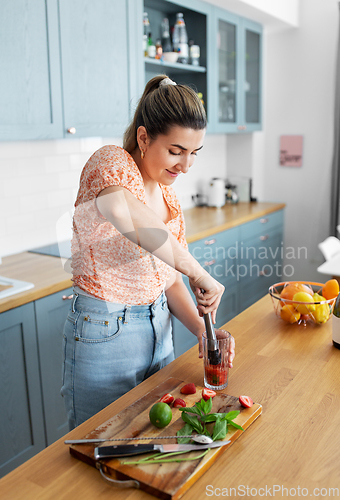 Image of woman making cocktail drinks at home kitchen