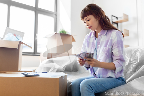 Image of asian woman moving to new home and counting money