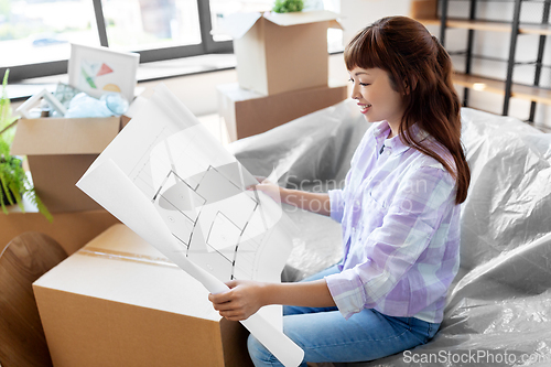 Image of woman with blueprint and boxes moving to new home