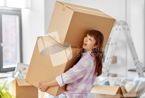 Image of woman holding heavy boxes and moving to new home