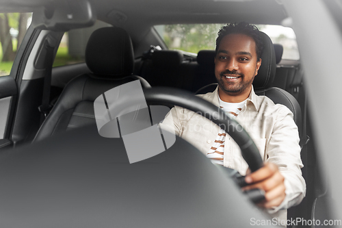 Image of smiling indian man or driver driving car