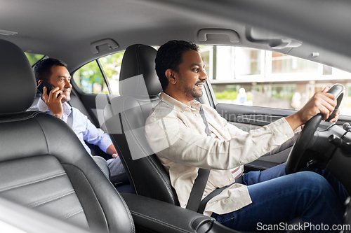 Image of male passenger calling on smartphone in taxi car