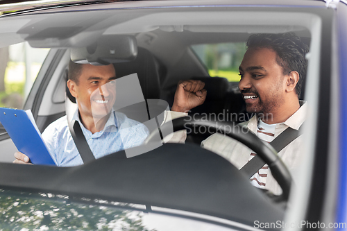 Image of smiling car driving school instructor and driver