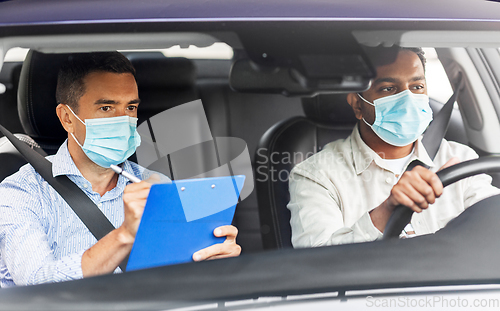 Image of car driving school instructor and driver in mask