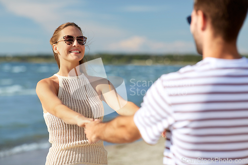 Image of happy couple hugging on summer beach