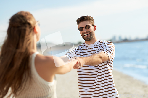 Image of happy couple hugging on summer beach