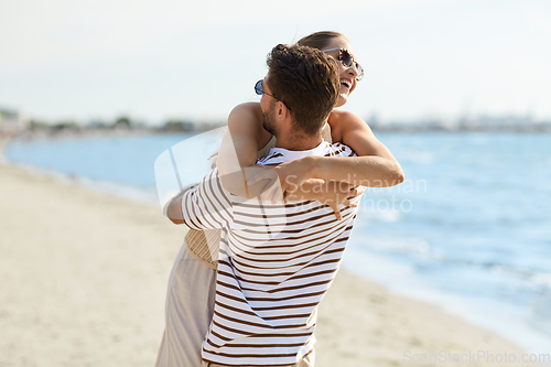 Image of happy couple hugging on summer beach