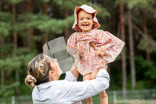 Image of happy smiling mother with baby girl outdoors
