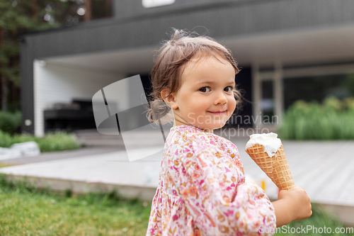 Image of happy little baby girl eating ice cream