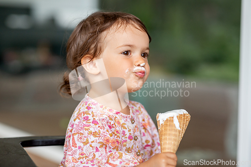 Image of happy little baby girl eating ice cream