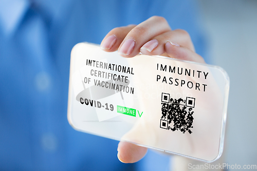 Image of hand with virtual immunity passport on smartphone