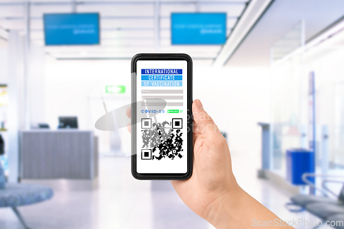 Image of hand holding phone with certificate of vaccination