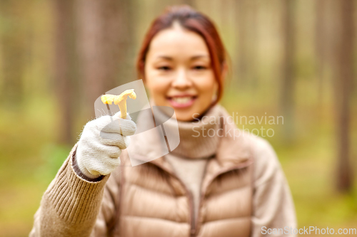 Image of young asian woman with mushroom in autumn forest