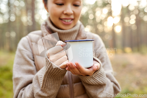 Image of asian woman with mug drinking tea in forest