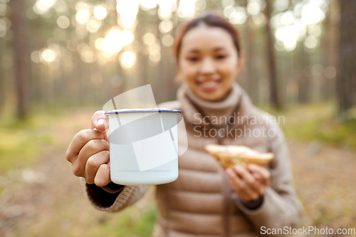 Image of asian woman with mug drinking tea in forest