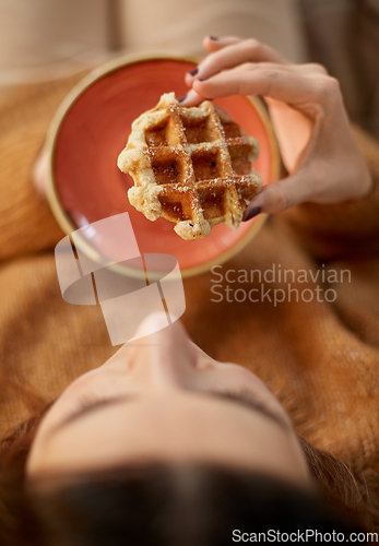 Image of close up of woman eating waffle at home