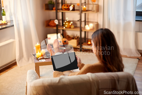 Image of woman with tablet pc at home on halloween