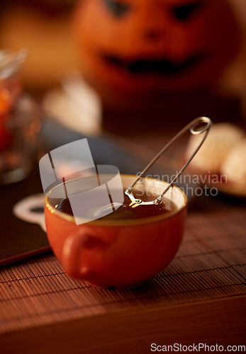 Image of mesh tea infuser ball in ceramic mug on halloween