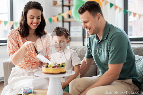 Image of happy family with birthday cake at home