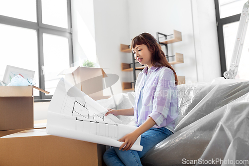 Image of woman with blueprint and boxes moving to new home
