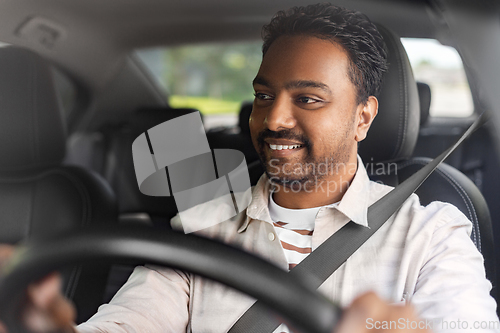 Image of smiling indian man or driver driving car