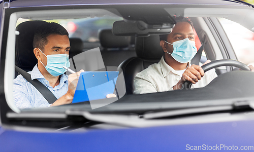 Image of car driving school instructor and driver in mask