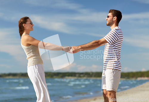 Image of happy couple hugging on summer beach