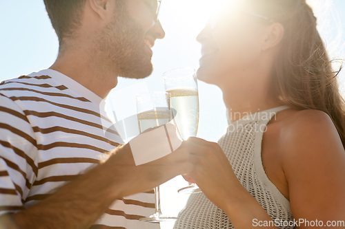 Image of happy couple drinking champagne on summer beach