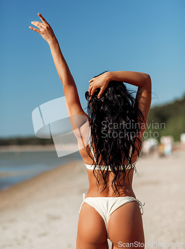 Image of young woman in bikini swimsuit on beach