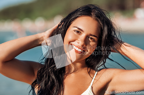 Image of smiling young woman in bikini swimsuit on beach