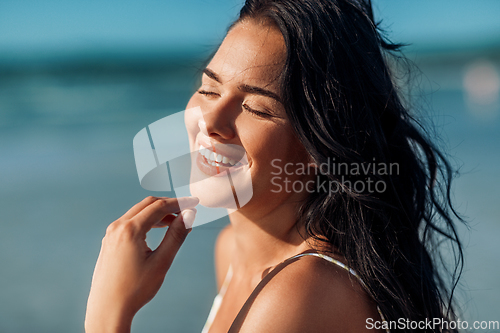 Image of close up of happy smiling young woman on beach