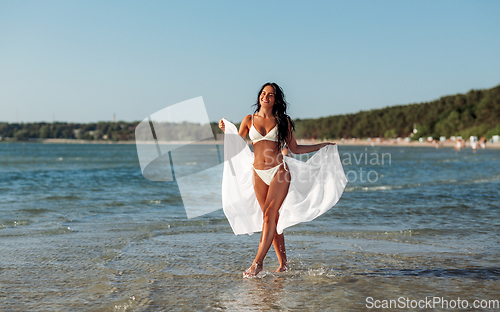 Image of woman in bikini swimsuit with cover-up on beach