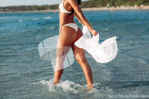 Image of woman in bikini swimsuit with cover-up on beach