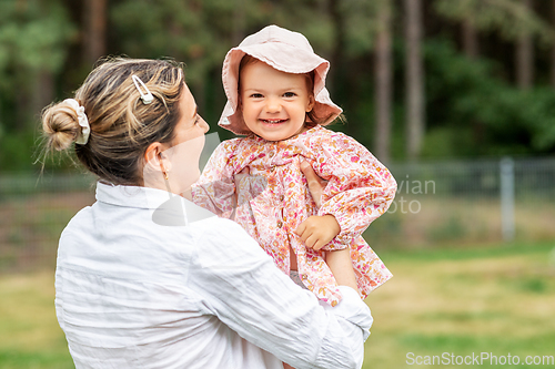 Image of happy smiling mother with baby girl outdoors